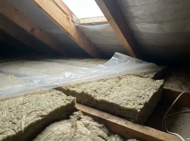 Minerale wol tussen de dakkepers geplaatst vanaf de binnenzijde, dampscherm gedeeltelijk geniet